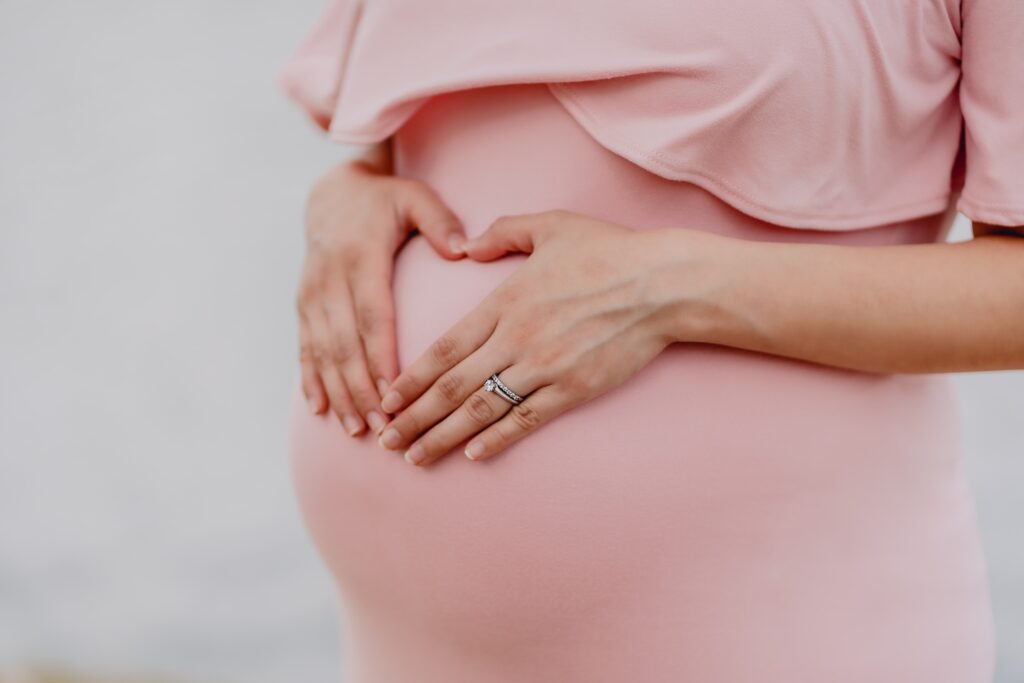 woman with hands on her pregnant belly